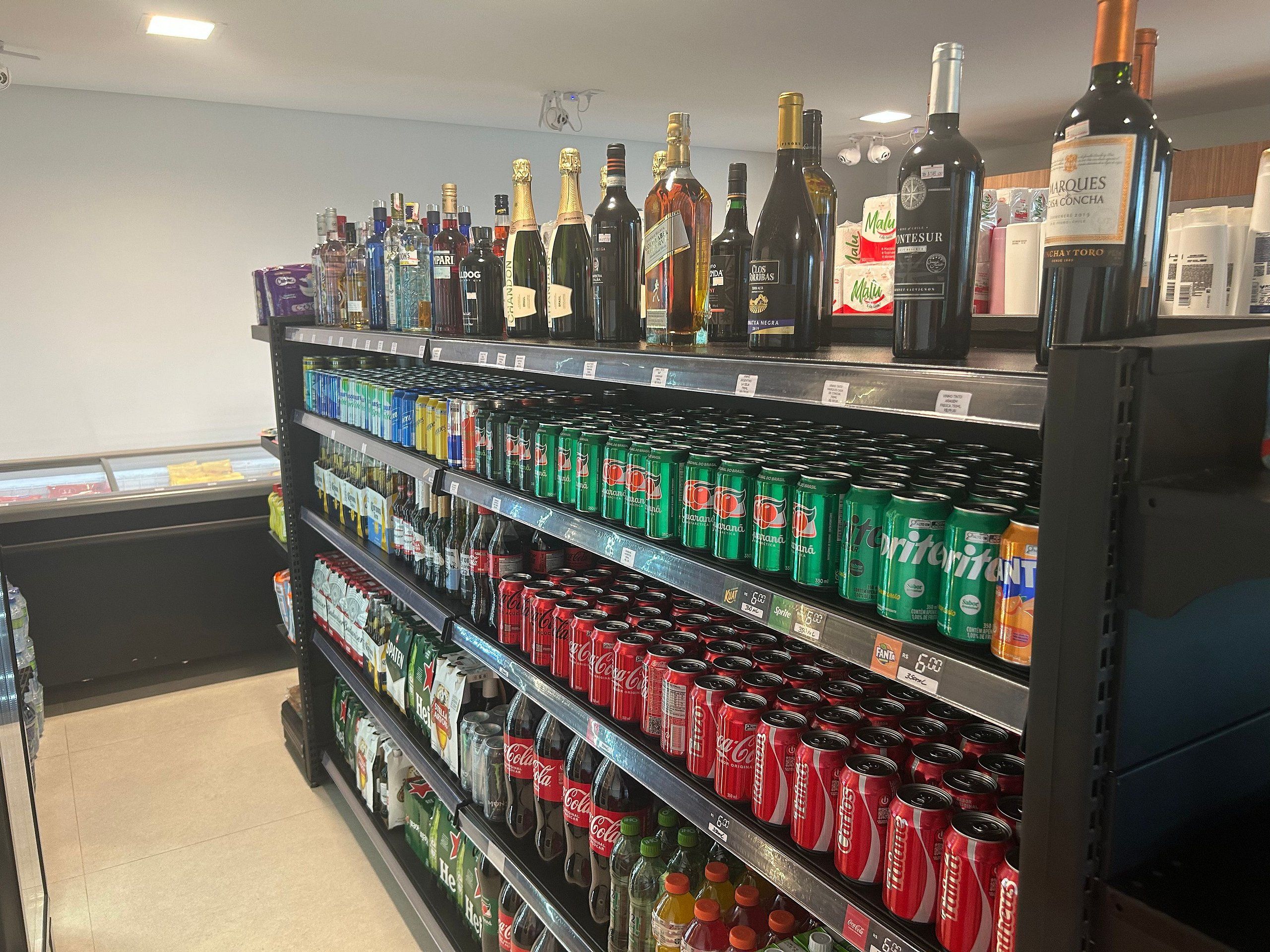A refrigerated section of a store with various beverages including bottled water, soda, and alcoholic drinks.