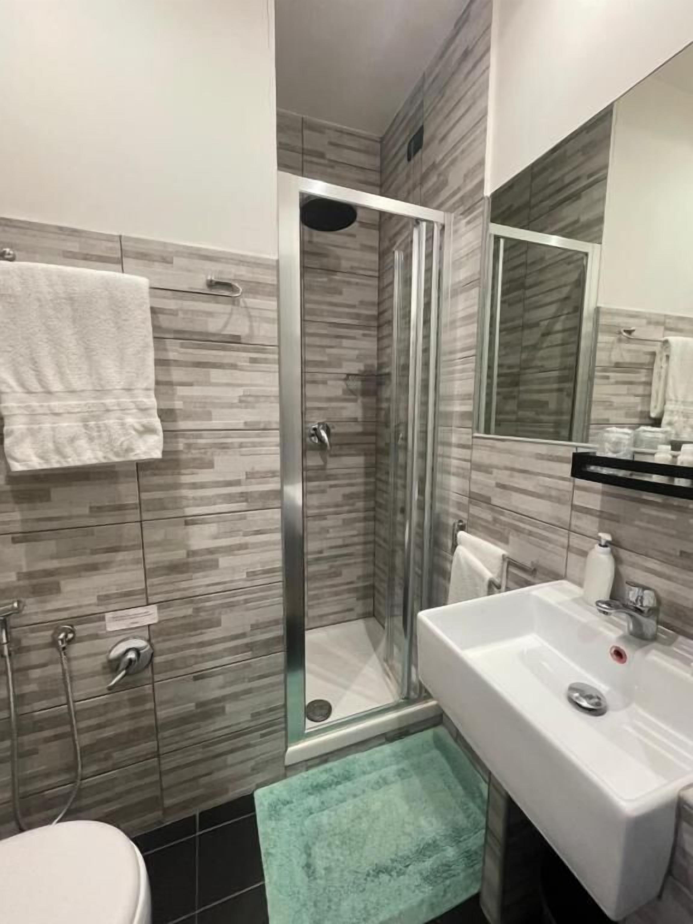 A bathroom with a shower, toilet, and sink.