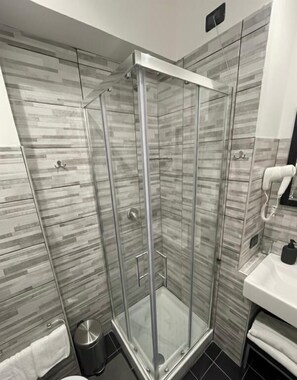 A modern bathroom with a glass shower enclosure, a white sink, and a tiled backsplash. - Residenza Cola di Rienzo - Suite In Rome (Rome)