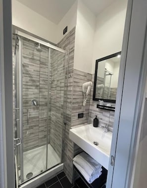 Economy tweepersoonskamer | Badkamer | Een douche, gratis toiletartikelen, een haardroger, pantoffels