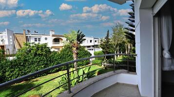 A balcony with a view of a residential area, including houses and greenery.