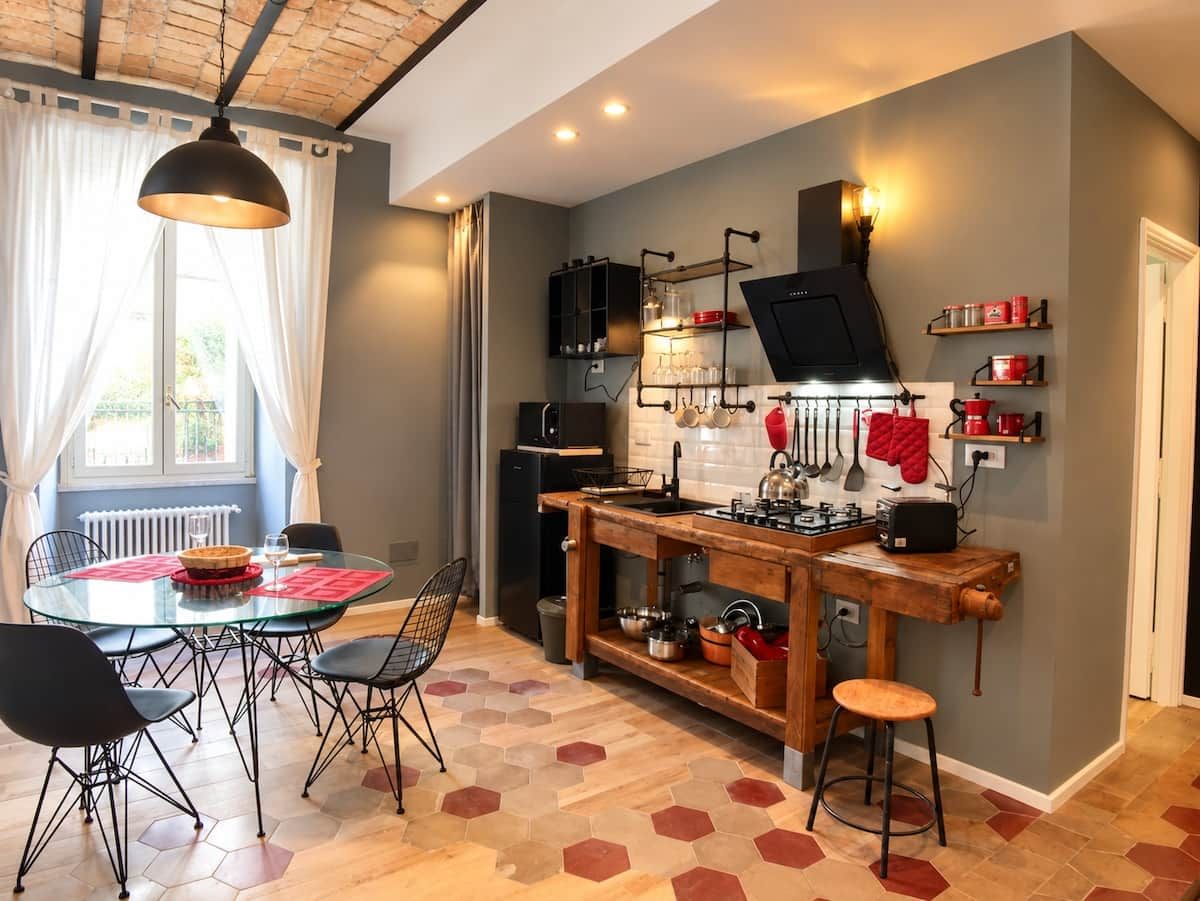 Une cuisine compacte avec un coin repas, comprenant une table ronde, des chaises et un tabouret de bar.