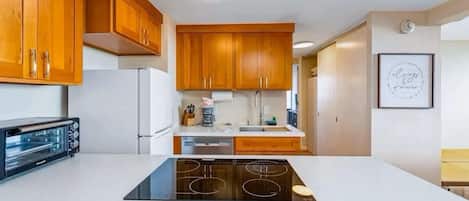 A kitchen with wooden cabinets, a built-in oven, and a central island with a stovetop.