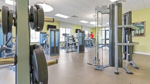 Ein Fitnessstudio mit verschiedenen Trainingsgeräten, darunter Kraftgeräte und Laufbänder.