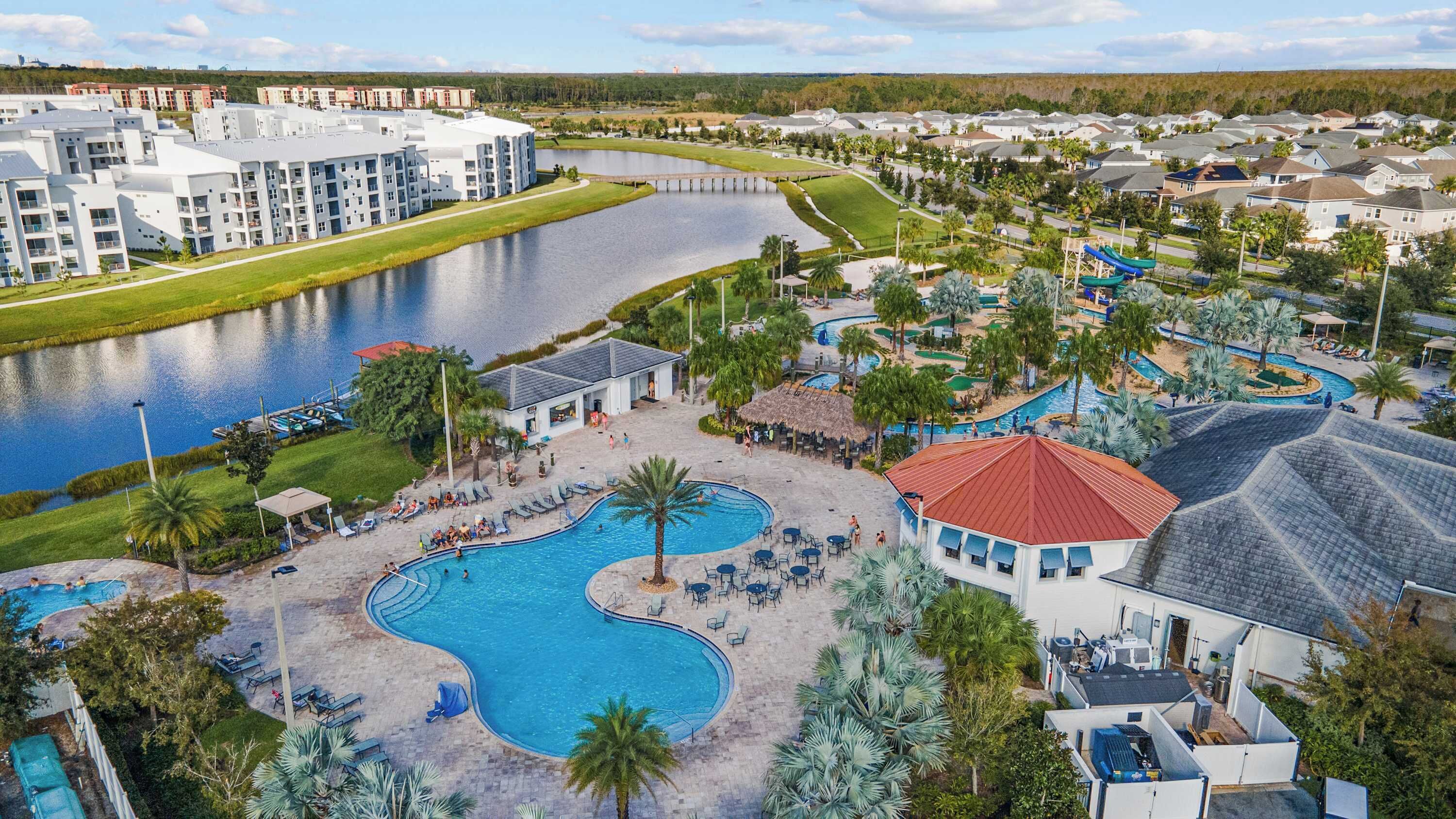 Un resort con una piscina grande, parque acuático y vista al río.