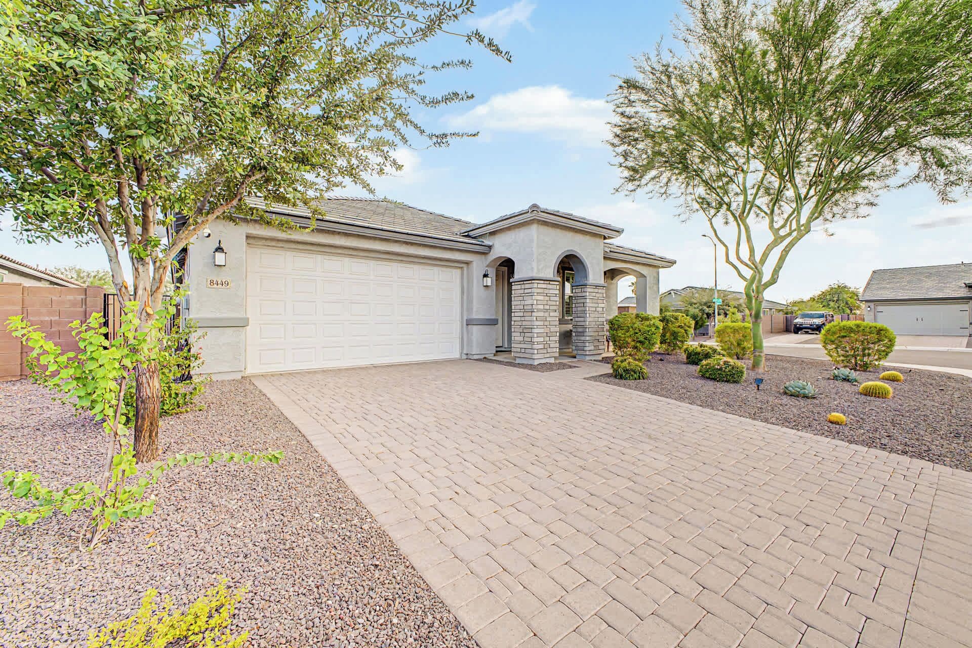A residential property with a garage, a driveway, and landscaping.