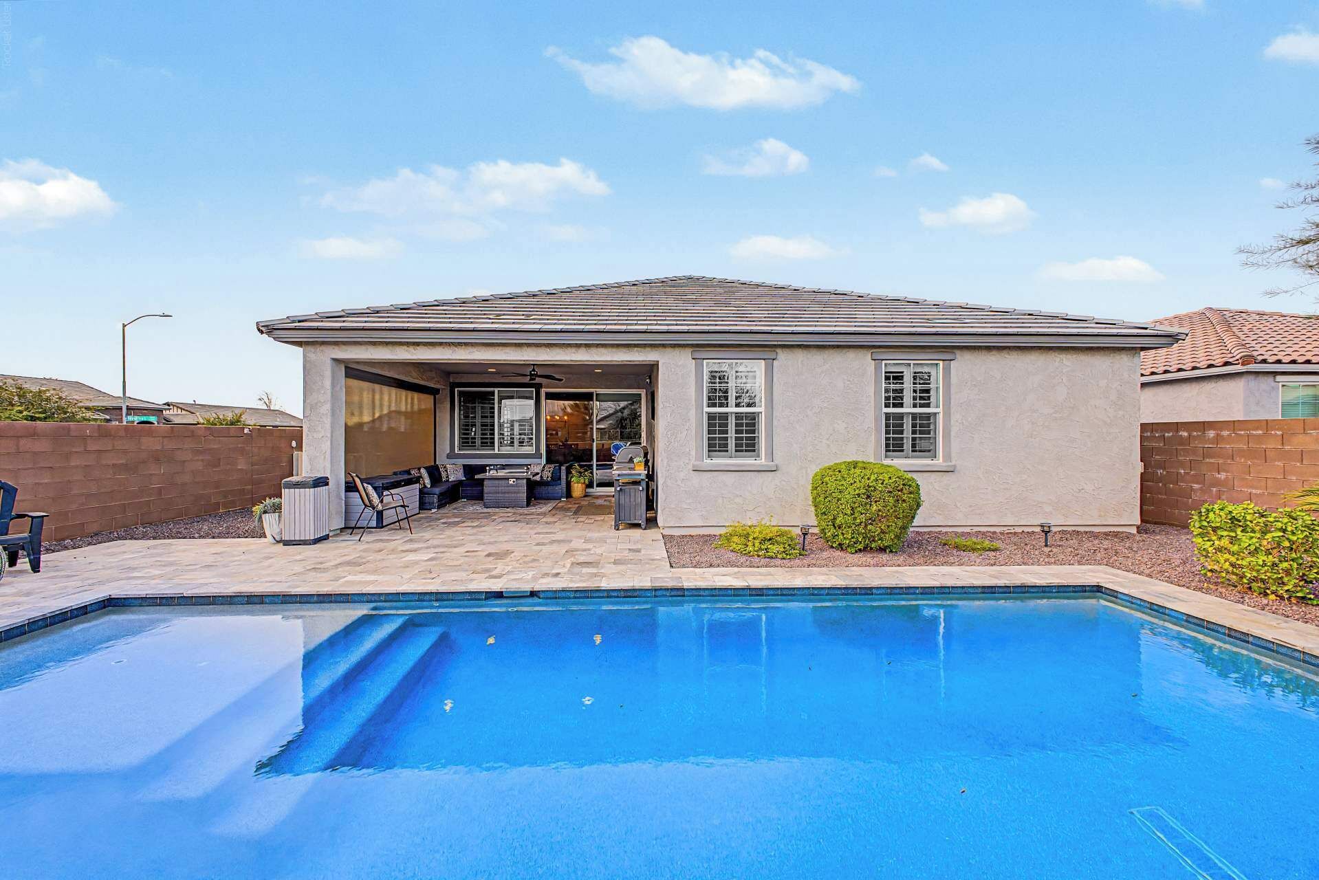 Um imóvel residencial com piscina, área de estar no pátio e espaço coberto ao ar livre.