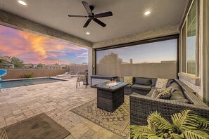 A covered patio with a pool, outdoor furniture, and a large window offering a view of the sky. - 4BR Stay | Westgate | Heated Pool, Fire Pit & BBQ (Glendale)