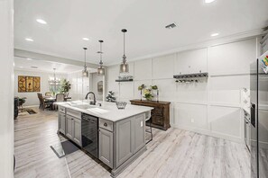 A modern kitchen with a central island, stainless steel appliances, and pendant lighting. - 4BR Stay | Westgate | Heated Pool, Fire Pit & BBQ (Glendale)