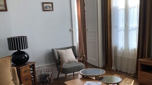 A living room with a sofa, armchair, coffee table, and a patterned rug. - 85, l ideal, Beautiful 2-bedroom apartment in peaceful Tours near city center (Tours)