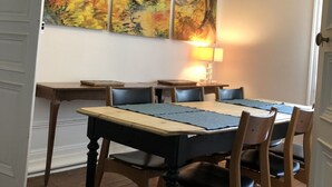 A dining area with a wooden table, chairs, and a chandelier. There are three paintings on the wall. - 85, l ideal, Beautiful 2-bedroom apartment in peaceful Tours near city center (Tours)