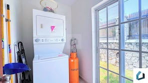 A laundry room with a white washing machine, a basket, and a gas cylinder. - Walk 2 Beach, Culture, Fun, Shops, Dine, Nightlife (Punta Cana)