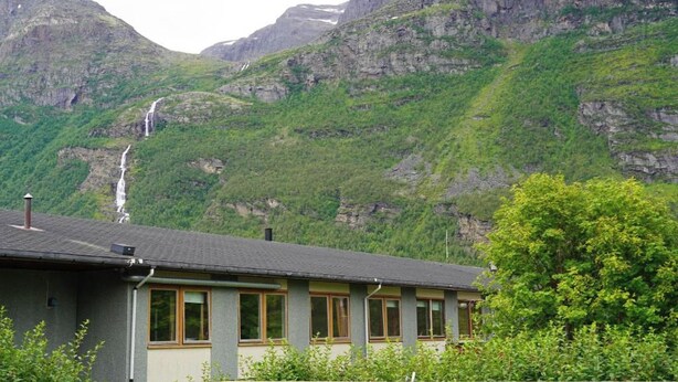 A building with a flat roof, multiple windows, and a visible chimney. - Birtavarre Aurora Adventures AS (Troms)