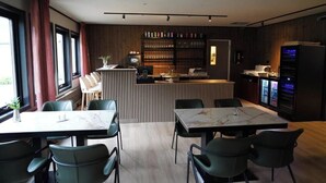 A modern restaurant with a bar area, seating for 8, and a view of the outdoors. - Birtavarre Aurora Adventures AS (Troms)
