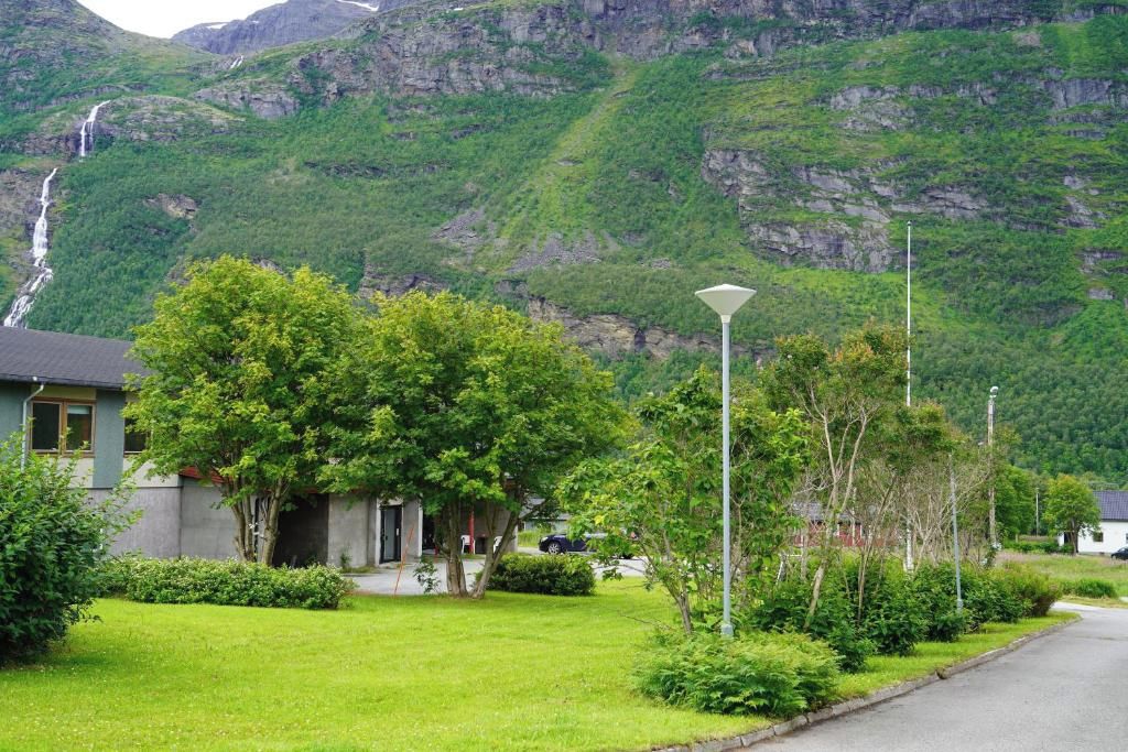 A residential area with houses, a well-maintained lawn, and a mountain backdrop.