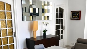 Uma sala de jantar com uma mesa, cadeiras, uma tigela decorativa, um abajur e um espelho na parede.