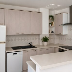 A modern kitchen with light wood cabinetry, a black sink, and a dishwasher. - Apartment 'Cannes Three Bedrooms' with Balcony, Wi-Fi and Air Conditioning (Cannes)