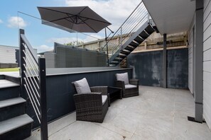 A patio area with outdoor furniture, a staircase, and a large umbrella. - Monkstone View - Direct Beach Access (Saundersfoot)