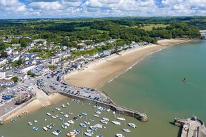 A coastal town with a sandy beach, a marina with numerous boats, and a fortified structure. - Monkstone View - Direct Beach Access (Saundersfoot)