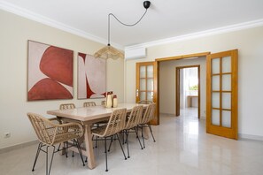 Ein Essbereich mit Tisch, Stühlen und einem Bild an der Wand.