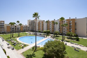A hotel with a swimming pool surrounded by palm trees and lounge chairs. - Moura Praia by Hdproperties (Vilamoura)