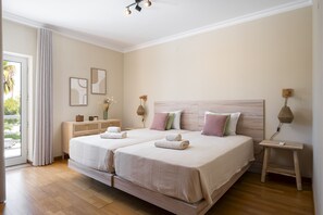 Ein Doppelbett mit zwei Kissen, ein Nachttisch, eine Lampe und ein Bild an der Wand.
