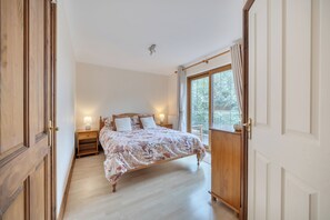 A bedroom with a bed, bedside tables, a wardrobe, and a window with curtains. - 2-bed - Sleeps 4 - Parking & Ev Charging (Wadebridge)