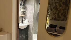 A modern bathroom with a vanity, sink, and a mirror with a leaf pattern. - Le Petit Rocher Doré: a unique getaway with a view of the Rock. (Pierrelatte)