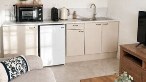 A compact kitchen with a microwave, coffee maker, and sink. - Le Petit Rocher Doré: a unique getaway with a view of the Rock. (Pierrelatte)
