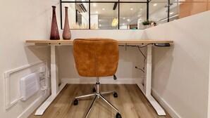 A modern office space with a wooden desk, a brown office chair, and a white radiator. - Luxury 2BR • 2.5 Bath Designer Home Retreat (Montréal)