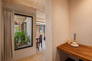 A modern interior with a wooden bench, a mirror, and a small plant arrangement. - Villa Romeo | Jungle & Caribbean • Rooftop Pool (Tulum)