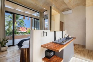 A modern bathroom with a wooden vanity, a large mirror, and a view of palm trees outside. - Villa Romeo | Jungle & Caribbean • Rooftop Pool (Tulum)