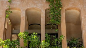 A building facade with three arches and climbing plants. - Villa Romeo | Jungle & Caribbean • Rooftop Pool (Tulum)