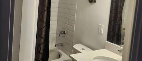 A bathroom with a toilet, a bathtub, and a sink.
