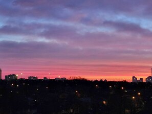 Un horizonte urbano al atardecer, con edificios silueteados contra un cielo colorido.