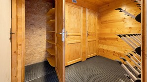 En bastu gjord av trä, med en bastubänk av metall, en dörr med ett nummer och ett ventilationssystem i taket.