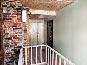 A staircase with a white railing leading to a door with a black frame.