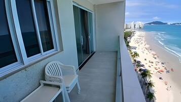 A balcony with a view of a beach and ocean.