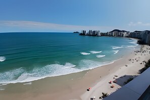 A beach with a clear view of the ocean and a city skyline in the background. - SHB - Vista incrível  e Pé na Areia  (Guarujá)