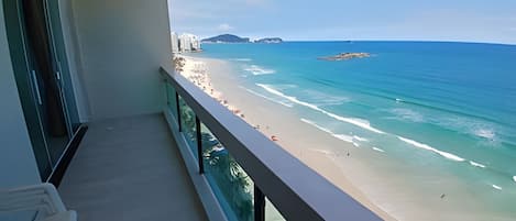A balcony with a view of a beach and ocean.