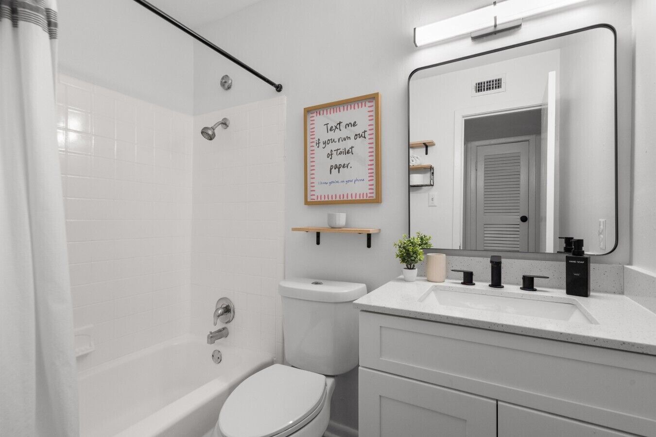A modern bathroom with a shower, toilet, and sink.