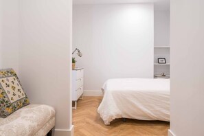 Ein Schlafzimmer mit einem Bett, einem Schminktisch und einem Sessel.