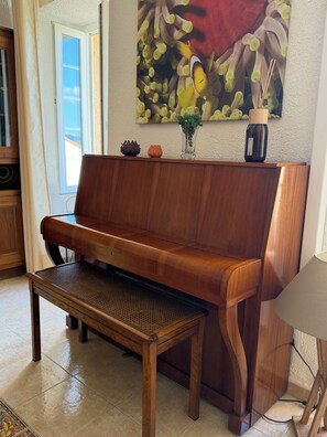 A wooden bench with a woven seat and backrest, positioned in a room with a tiled floor. - Spacious Apartment with Mountain Views - Free Parking - Near ÎLE ROUSSE (Belgodère)