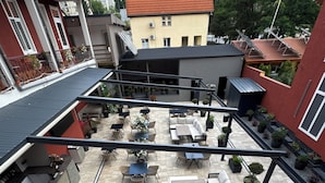 A rooftop patio with outdoor seating, a pool, and a view of the cityscape.