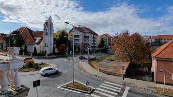 A street view with a church, residential buildings, and a pedestrian crossing.