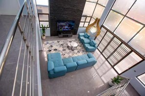A modern living area with a sectional sofa, a coffee table, and a fireplace.