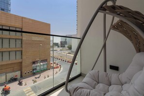 Ein modernes Zimmer mit großem Fenster, einer gepolsterten Sitzecke und Blick auf die Straße.