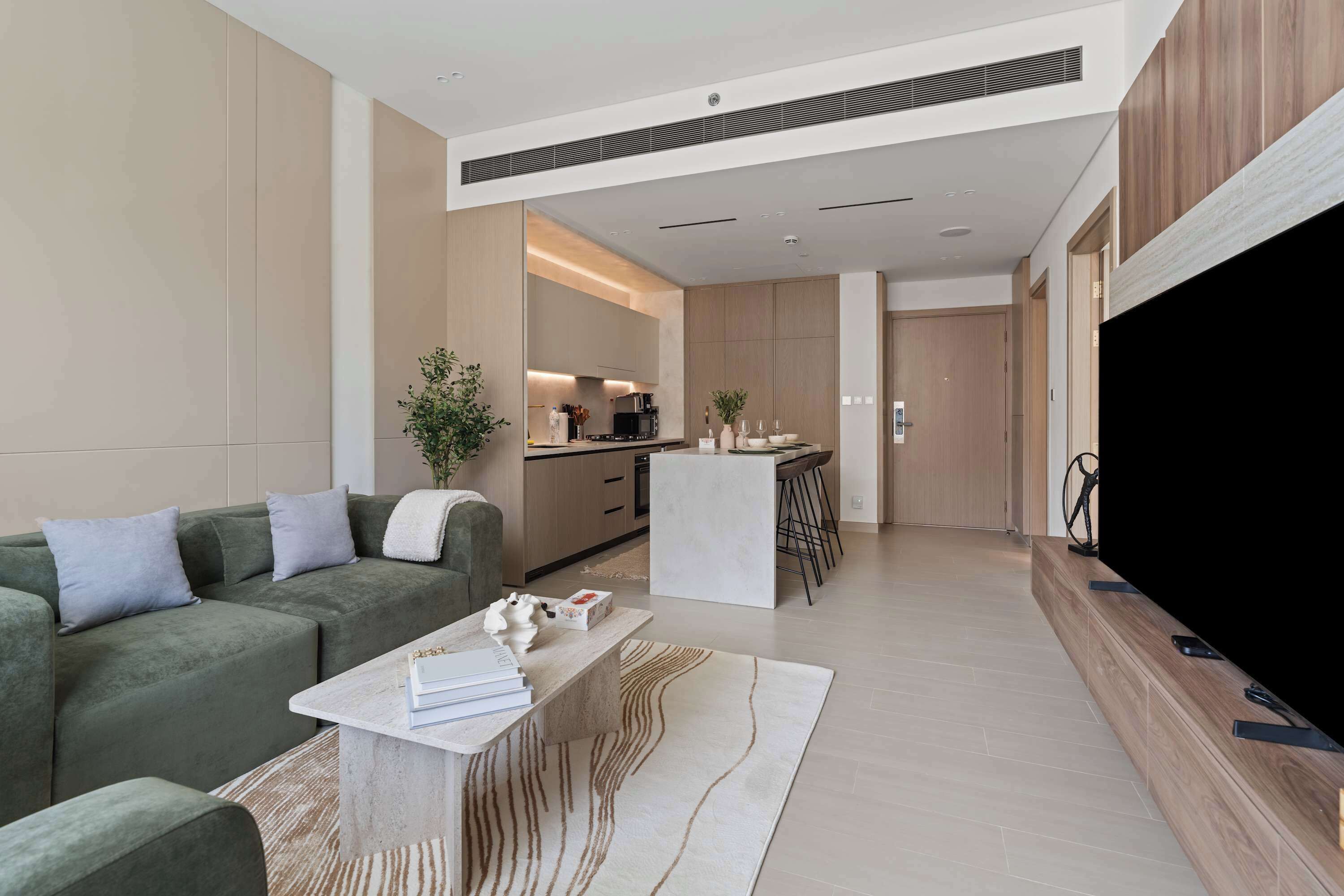 A modern living room with a sofa, coffee table, and a TV.