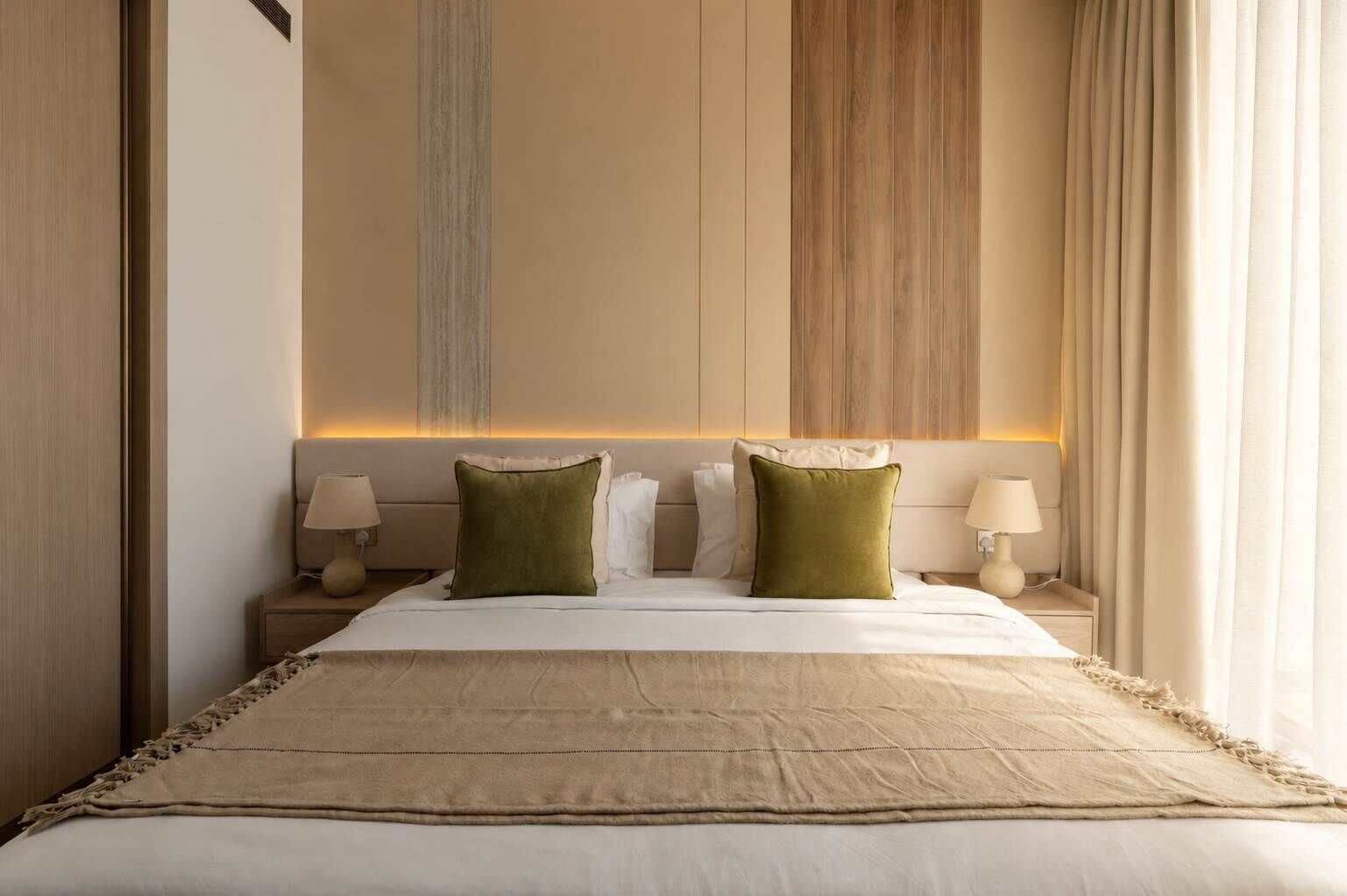 Een hotelkamer met een groot bed, twee nachtkastjes en een hoofdbord met verticale houten panelen.