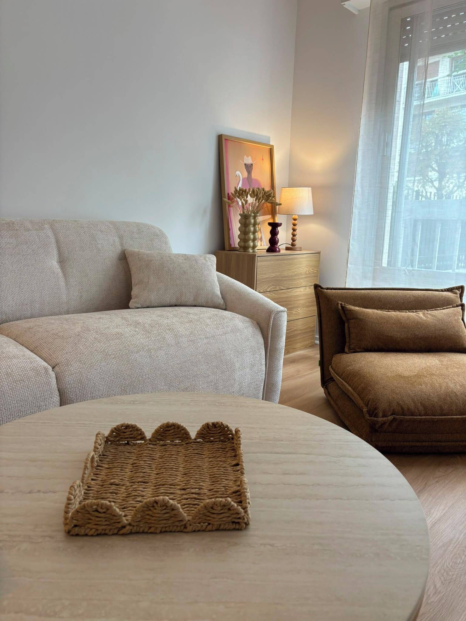 A living room with a sofa, a smaller couch, a round coffee table, and a side table with a lamp.